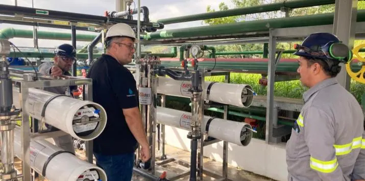 Equipe técnica Aclaris em campo, avaliando instalação industrial com equipamentos de proteção