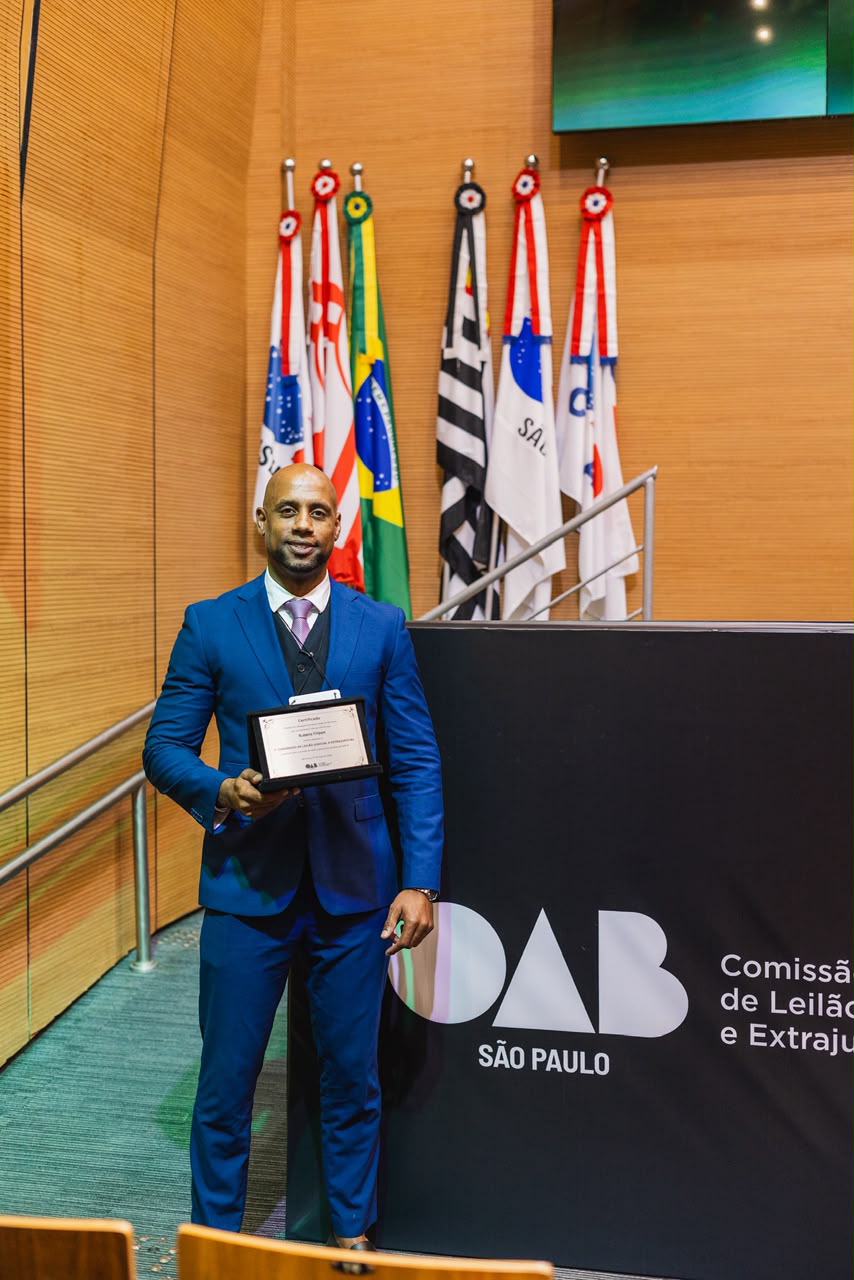 Dr. Rubens Filippe de Jesus segurando o certificado do 1º Congresso de Leilão Judicial e Extrajudicial, no auditório da OAB São Paulo